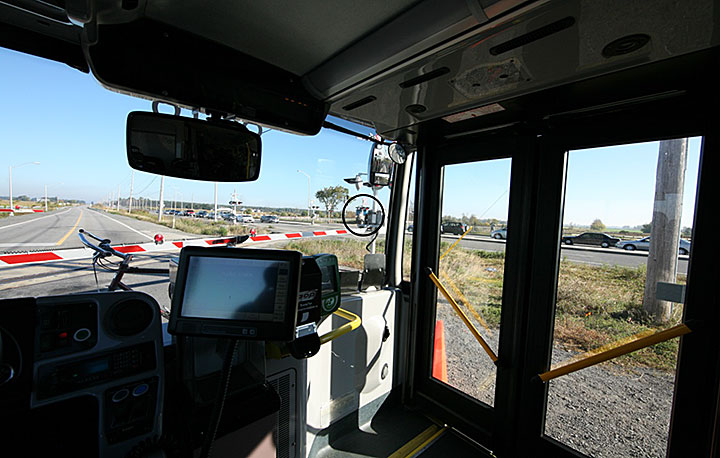 Image du vue grand angle du train en approche à partir d'un autobus arrêté au passage à niveau