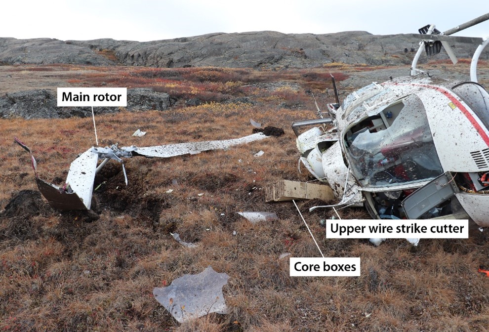 Photo of the wreckage showing the helicopter on its right side, the main rotor and the core boxes (Source: Royal Canadian Mounted Police)
