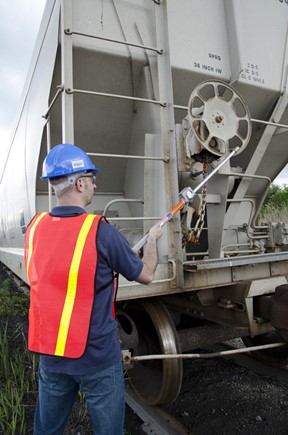 Conductor using a brake stick to apply a hand brake from the ground (Source: Aldon Company, Inc.)
