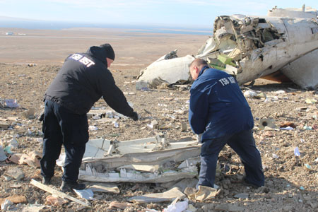 Deux enquêteurs examine l'épave à l'endroit de l'événement