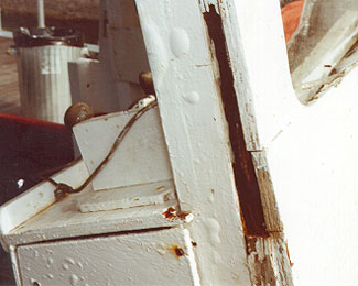 Désintégration due à la pourriture sèche de l'avant de la superstructure faite de contreplaqué, au droit du cadre de la porte avant.